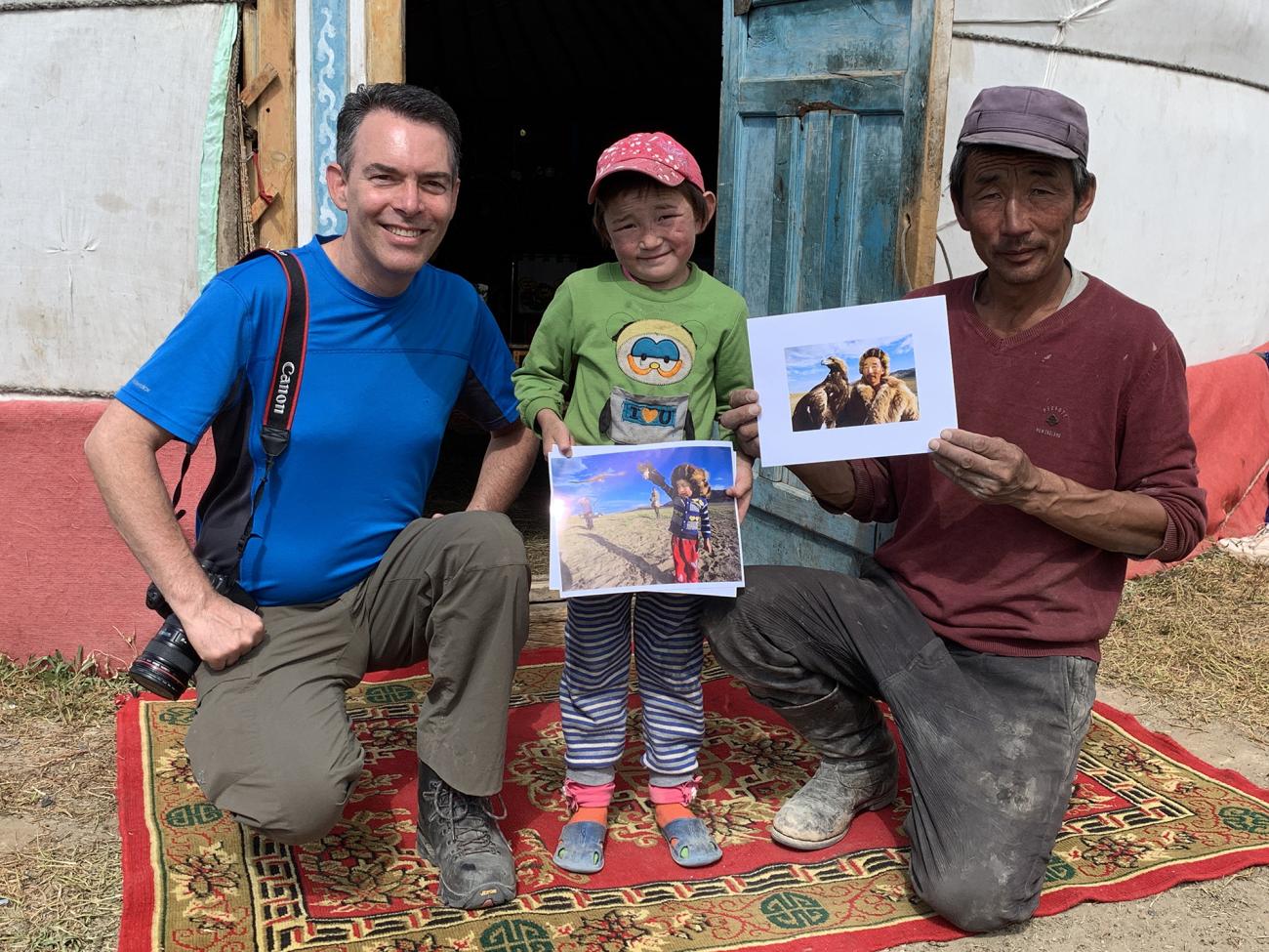 Western Professor David Sattler with Mongolian boy and older man holding photos in front of Ger.  Photo 10