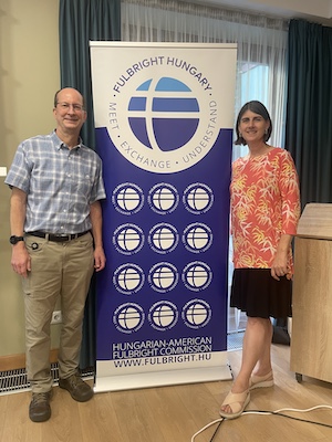 Mark Bussell and Kristi Lemm standing next to Fulbright Hungary banner.